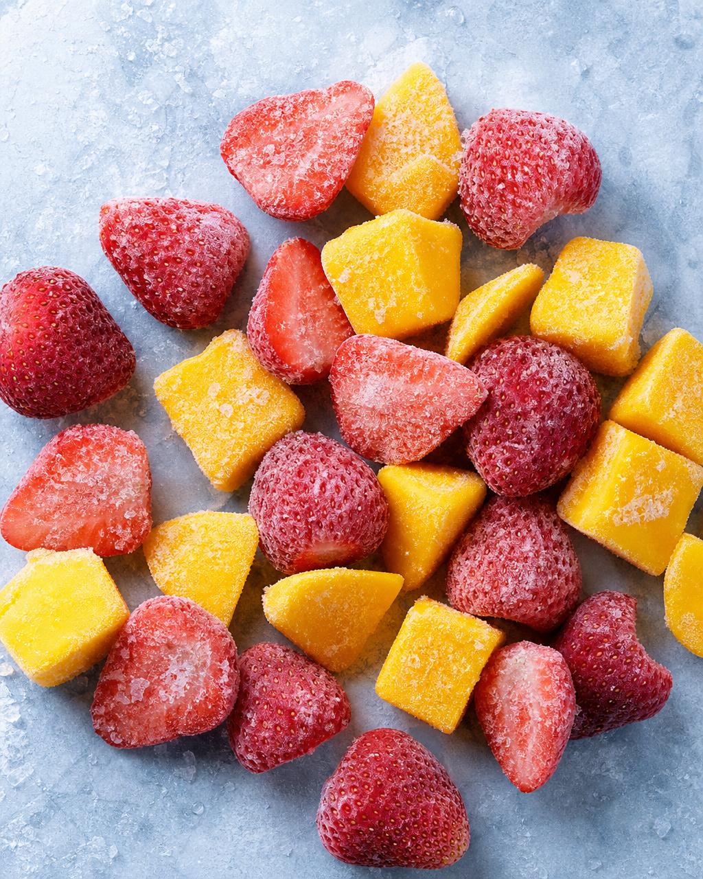 Frozen strawberries and mango chunks coated with frost
